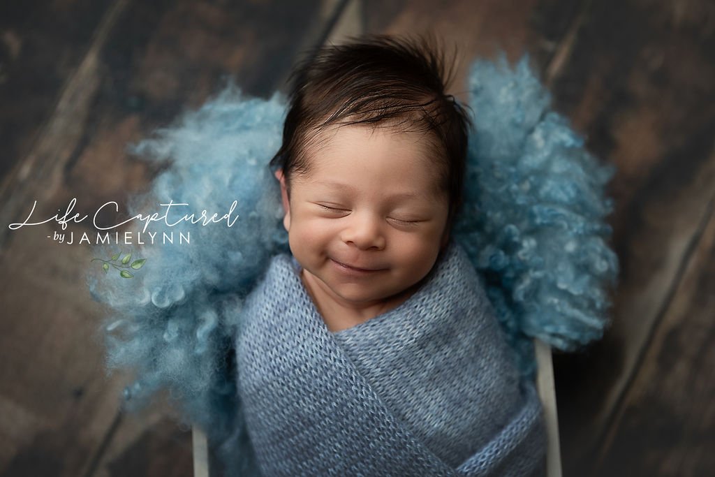 smiling newborn, posed using safe studio practices