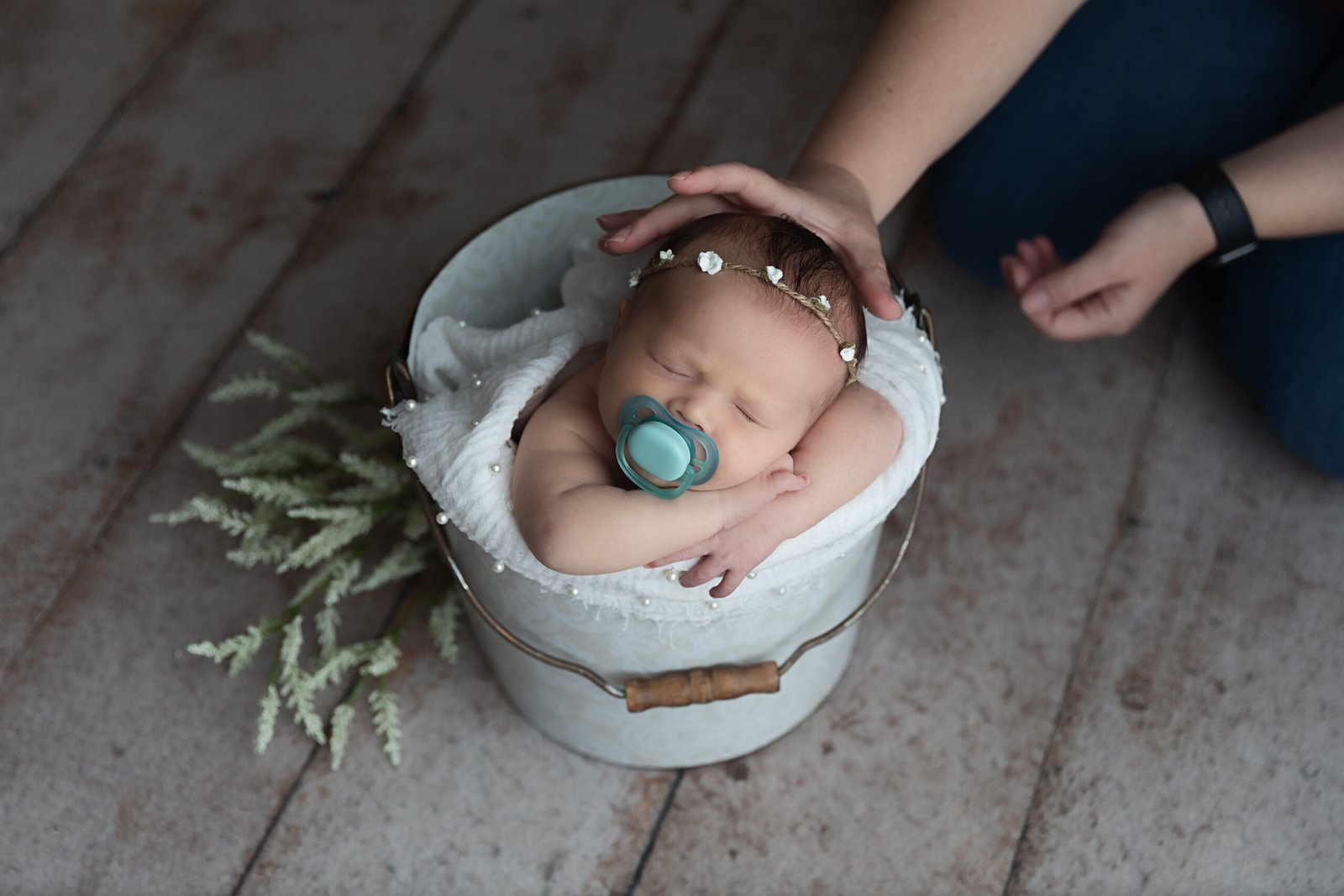 baby being posed during photo session with pacifier